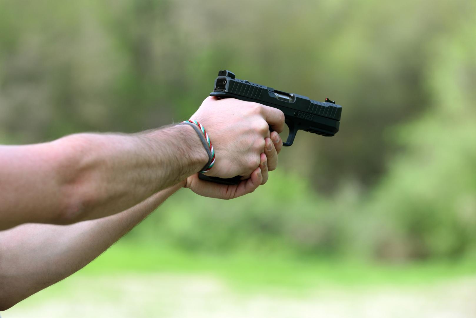 persona sosteniendo un arma de fuego