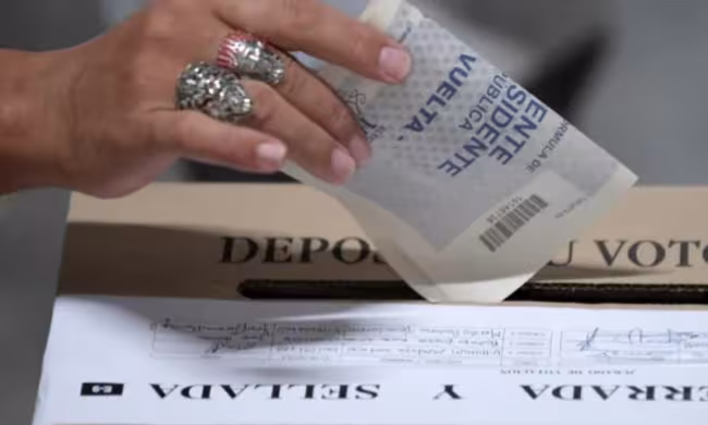 Persona ingresando el vota a la urna 