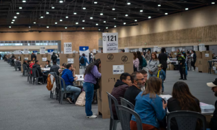 Puesto de votación lleno de electores ejerciendo libremente su derecho al voto
