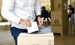 Hombre depositando su voto en una urna de votación